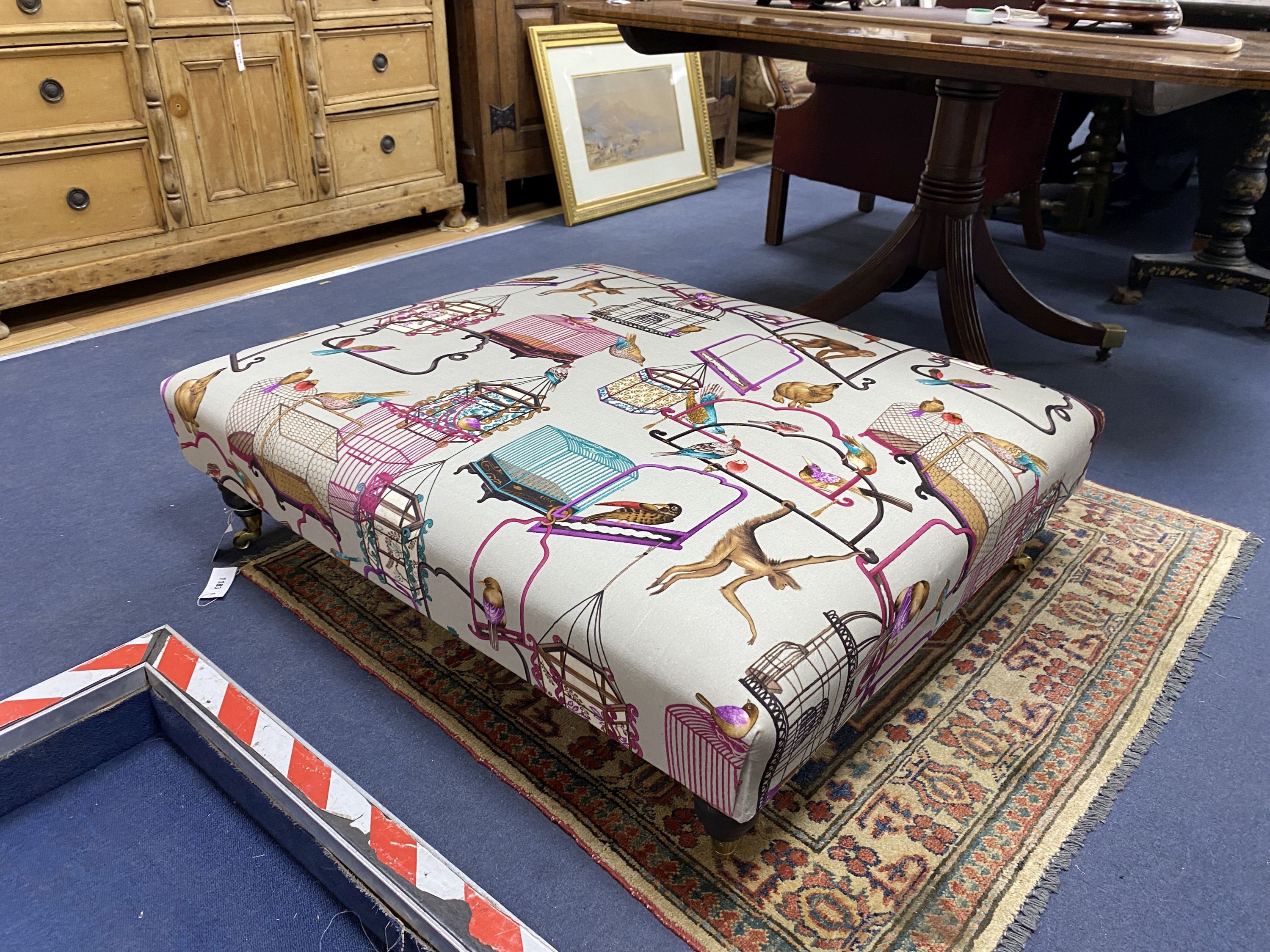 A Victorian-style rectangular footstool, upholstered in menagerie fabric, width 106cm, height 90cm